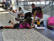 FILE - Passengers whose flights were cancelled sit at the departure terminal ground of Rafik Hariri International Airport in Beirut, Lebanon, Aug. 5, 2024.