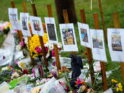 FILE - Rain-soaked memorials for those who died in a mass shooting sit along the roadside by Schemengees Bar &amp; Grille, Oct. 30, 2023, in Lewiston, Maine.