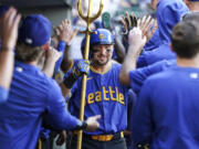 Seattle Mariners&#039; Cal Raleigh celebrates with teammates after hitting a home run during the sixth inning of a baseball game against the New York Mets, Sunday, Aug. 11, 2024, in Seattle.