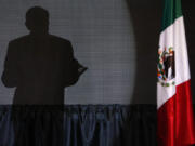 FILE - The shadow of presidential candidate Andres Manuel Lopez Obrador, founder of the ruling party, Morena, is cast on a screen as he gives his first victory speech at his campaign headquarters at the Hilton hotel in Mexico City, late July 1, 2018.