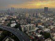 FILE - The sun sets in Mexico City after heavy rain, July 25, 2024.