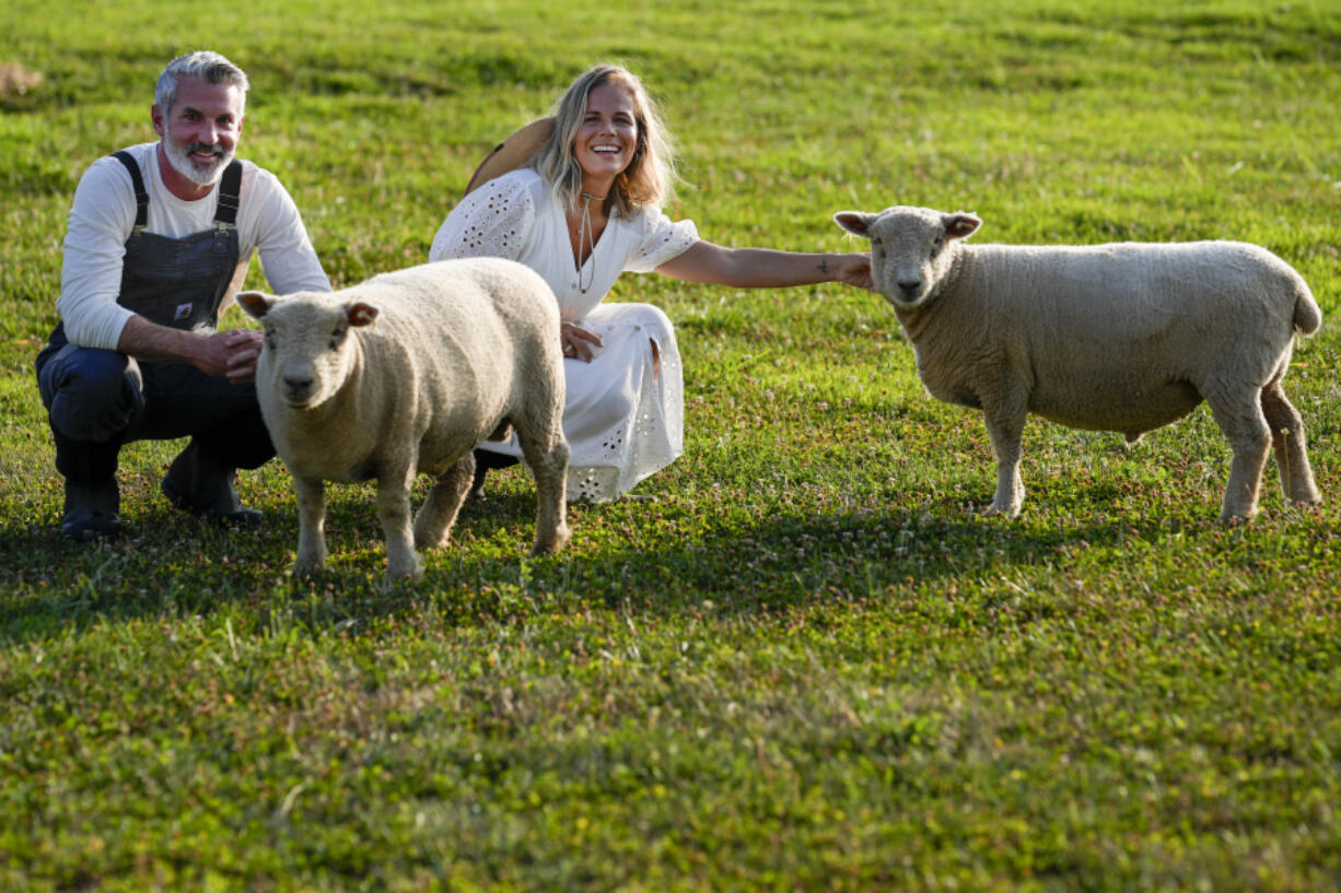 Jeff and Jamie Campion pose July 3 with their Southdown Babydoll sheep Buttermilk and Biscuit in their backyard in Thompson Station, Tenn.