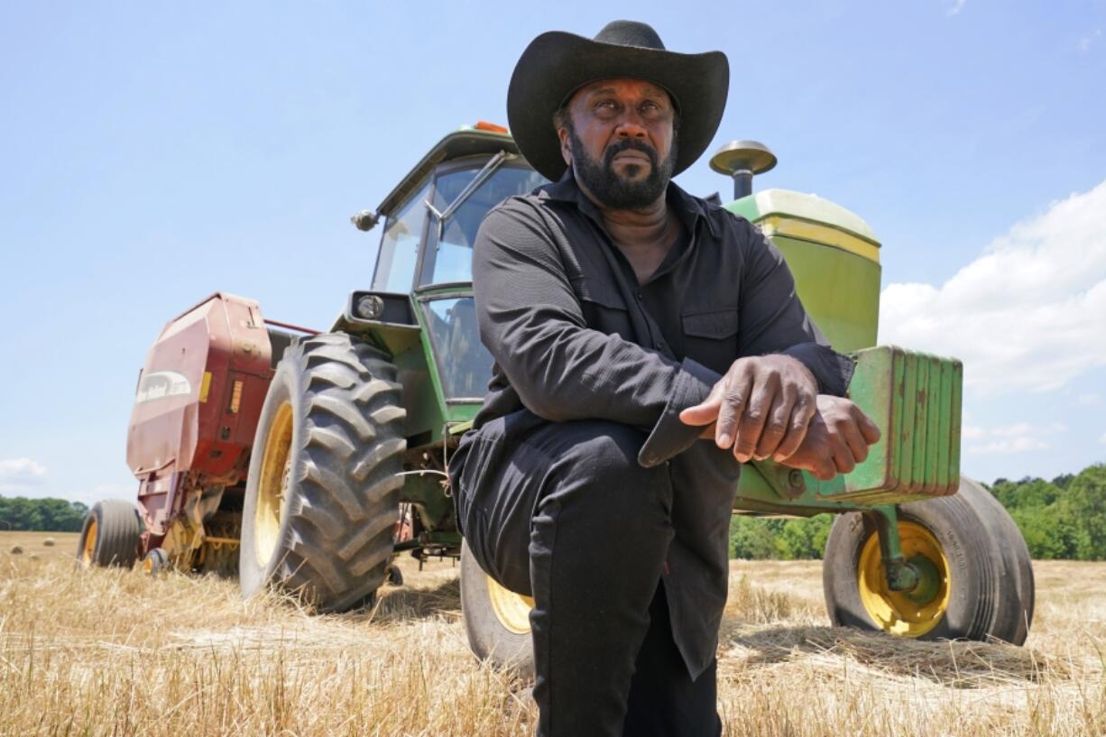 FILE - Farmer John Boyd Jr., poses for a portrait during a break from bailing hay at his farm in Boydton, Va., Thursday, May 27, 2021.