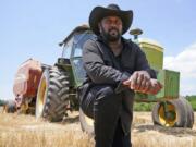 FILE - Farmer John Boyd Jr., poses for a portrait during a break from bailing hay at his farm in Boydton, Va., Thursday, May 27, 2021.