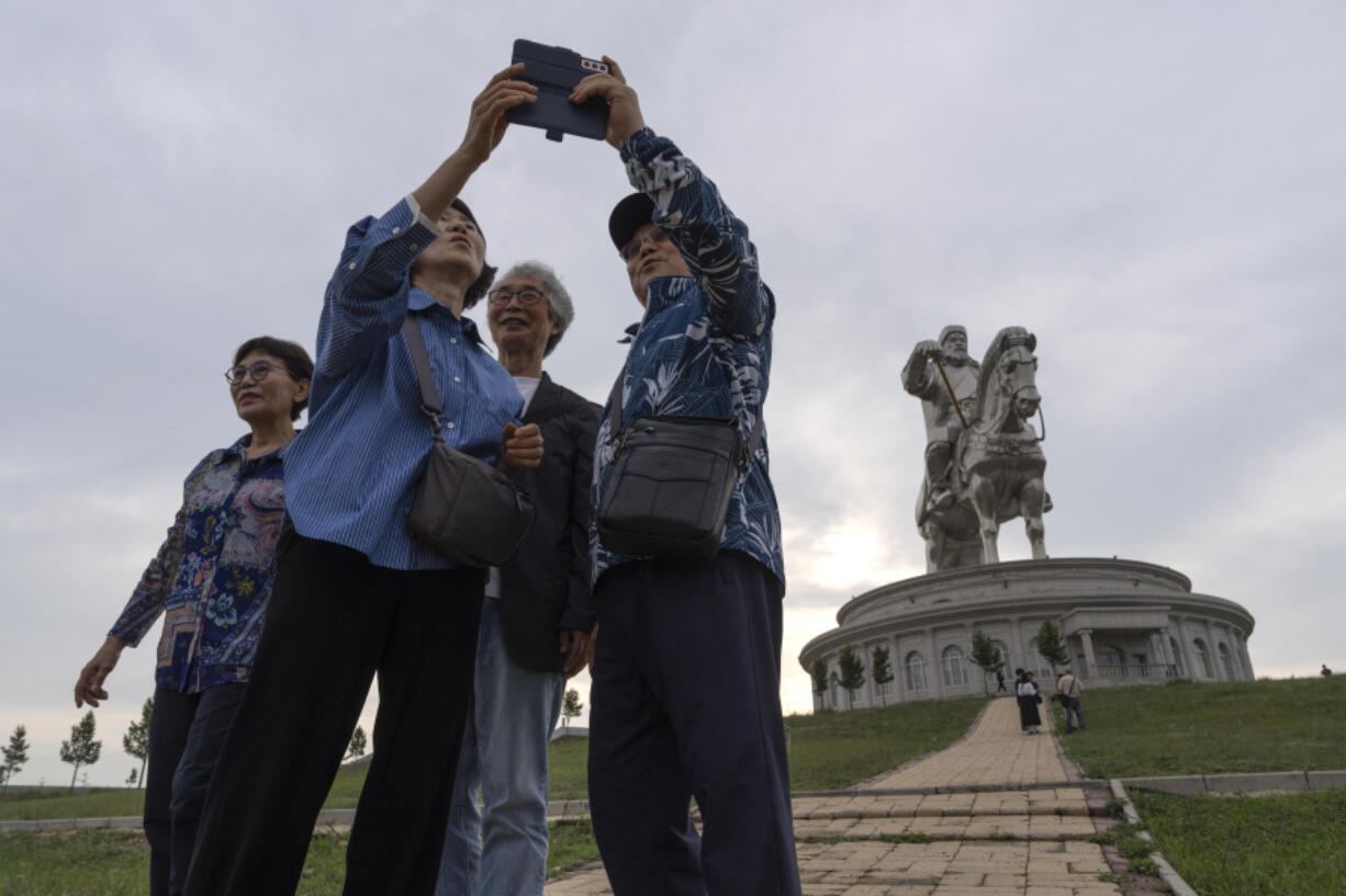 Tourists take photos July 1 near the 130-foot-tall stainless steel statue of Genghis Khan, a national hero who amassed power to become the leader of the Mongols in the early 13th century on the outskirts of Ulaanbaatar, Mongolia.