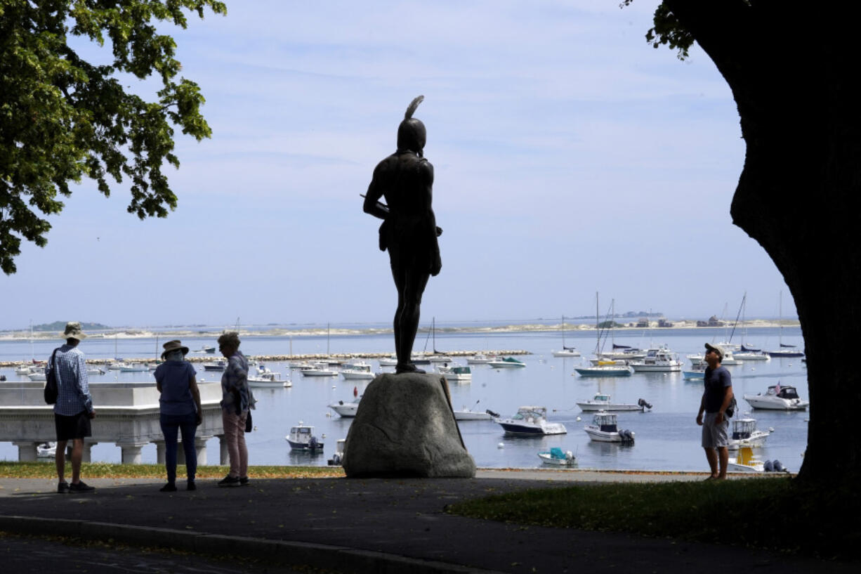 FILE - Visitors stand near a 1921 statue of the Wampanoag leader Massasoit, center, Wednesday, June 9, 2021, on Cole&rsquo;s Hill, in Plymouth, Mass. The town of Plymouth announced Friday, Aug. 23, 2024, that it&rsquo;s closing public outdoor recreation facilities from dusk until dawn each day after a horse in the town was infected with eastern equine encephalitis.