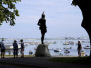 FILE - Visitors stand near a 1921 statue of the Wampanoag leader Massasoit, center, Wednesday, June 9, 2021, on Cole&rsquo;s Hill, in Plymouth, Mass. The town of Plymouth announced Friday, Aug. 23, 2024, that it&rsquo;s closing public outdoor recreation facilities from dusk until dawn each day after a horse in the town was infected with eastern equine encephalitis.