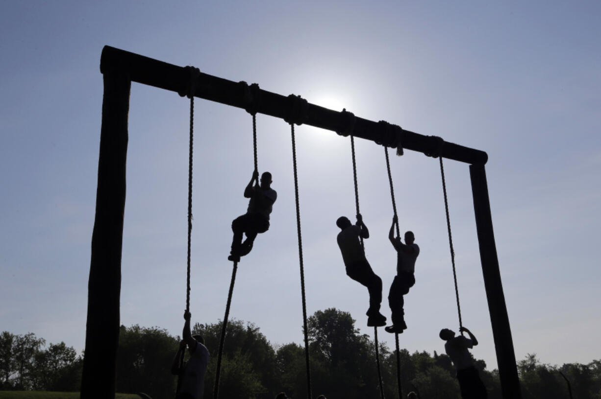 FILE - Freshman midshipmen, known as plebes, climb ropes on an obstacle course during Sea Trials, a day of physical and mental challenges that caps off the freshman year at the U.S. Naval Academy in Annapolis, Md., May 13, 2014.