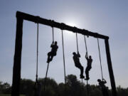 FILE - Freshman midshipmen, known as plebes, climb ropes on an obstacle course during Sea Trials, a day of physical and mental challenges that caps off the freshman year at the U.S. Naval Academy in Annapolis, Md., May 13, 2014.