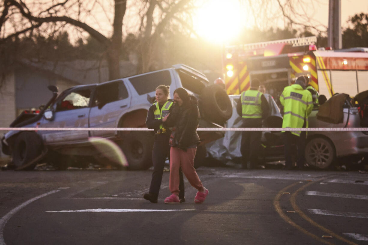 A police officer comforts a woman at a crash site near Geraldine, New Zealand, where South Korean skiers are involved in a fatal accident, Thursday, Aug. 22, 2024.