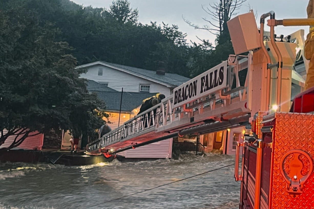 This photo provided by Beacon Hose Co. No. 1, a fire station in Beacon Falls, Connecticut, shows members of Beacon Hose Co. rescuing people from the Brookside Inn in Oxford, Conn., Sunday, Aug. 18, 2024.