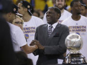 FILE -G olden State Warriors guard Stephen Curry, left, shakes hands with former coach Al Attles after Game 5 of the NBA basketball Western Conference finals against the Houston Rockets in Oakland, Calif., Wednesday, May 27, 2015.