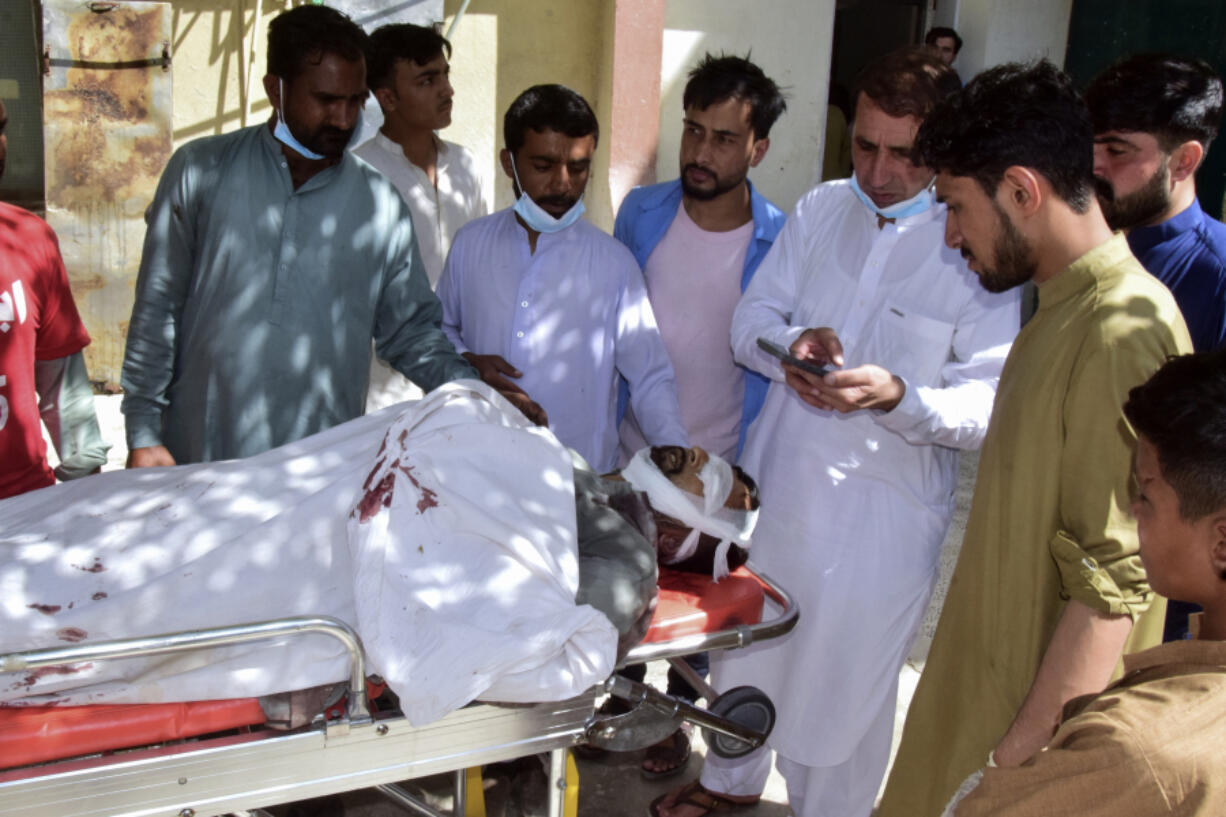 Relatives gather around a body of a passenger, killed by gunmen at a highway in Musakhail, as they wait for transportation at a hospital, in Quetta, Pakistan, Monday, Aug. 26, 2024.