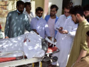 Relatives gather around a body of a passenger, killed by gunmen at a highway in Musakhail, as they wait for transportation at a hospital, in Quetta, Pakistan, Monday, Aug. 26, 2024.