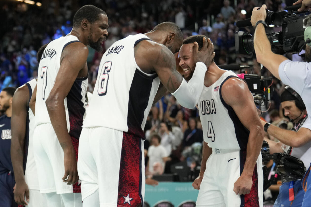 United States&#039; Kevin Durant (7), LeBron James (6) and Steph Curry (4) celebrate after beating Serbia during a men&#039;s semifinals basketball game at Bercy Arena at the 2024 Summer Olympics, Thursday, Aug. 8, 2024, in Paris, France. (AP Photo/Mark J.