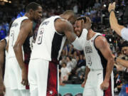 United States&#039; Kevin Durant (7), LeBron James (6) and Steph Curry (4) celebrate after beating Serbia during a men&#039;s semifinals basketball game at Bercy Arena at the 2024 Summer Olympics, Thursday, Aug. 8, 2024, in Paris, France. (AP Photo/Mark J.