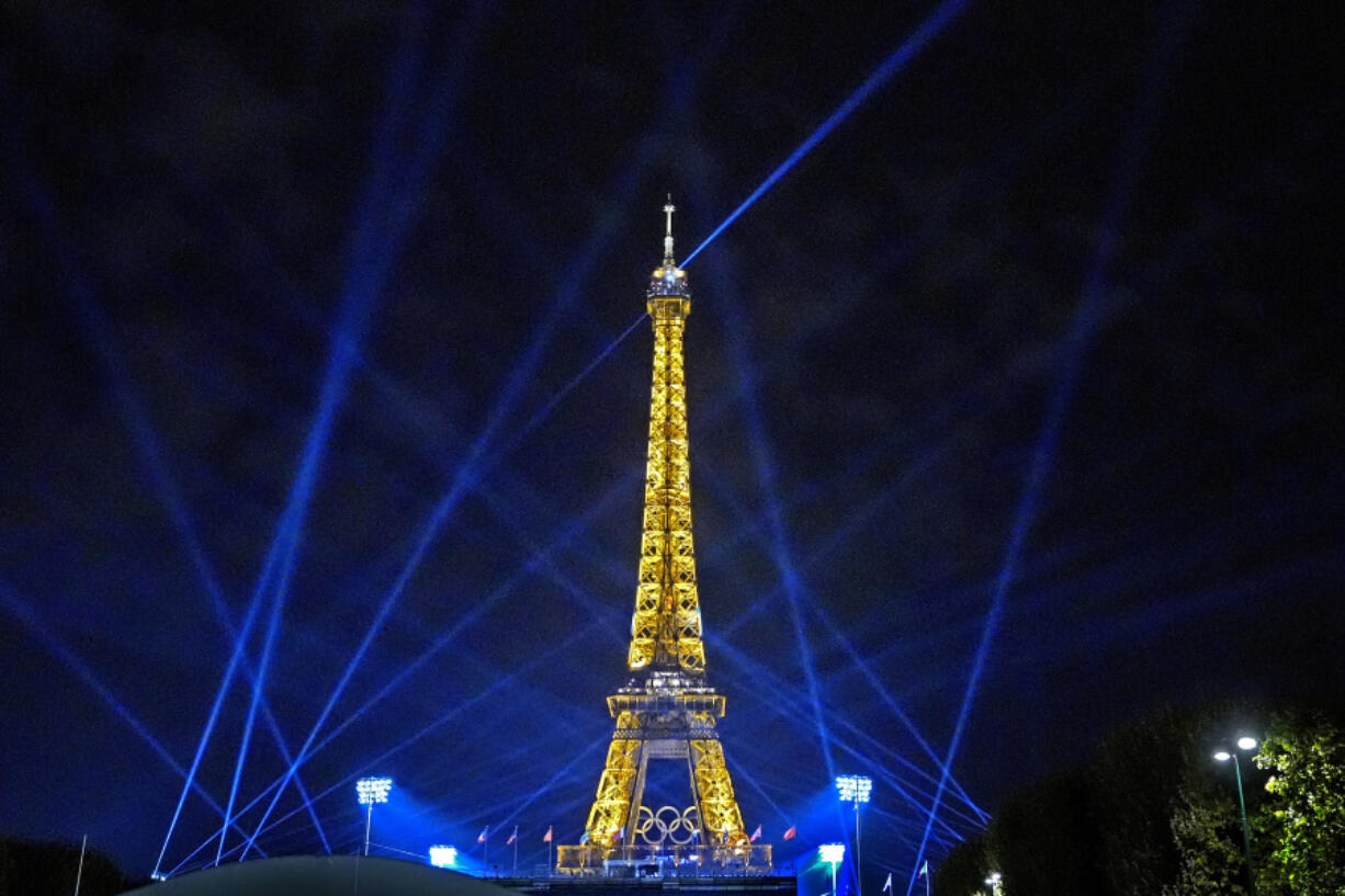 Search lights shine above Eiffel Tower Stadium, the beach volleyball venue at the 2024 Summer Olympics, Tuesday, July 30, 2024, in Paris, France. (AP Photo/Robert F.