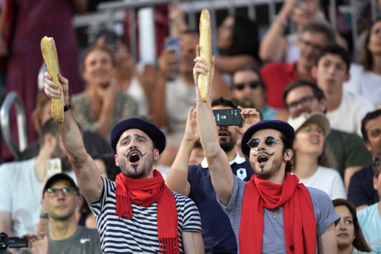 Thomas Zellner, left and Thibault Vinson celebrate being Parisian while cheering for France&#039;s Lezana Placette and Alexia Richard in a beach volleyball match against Germany at the 2024 Summer Olympics, Monday, July 29, 2024, in Paris, France. (AP Photo/Robert F.