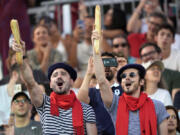 Thomas Zellner, left and Thibault Vinson celebrate being Parisian while cheering for France&#039;s Lezana Placette and Alexia Richard in a beach volleyball match against Germany at the 2024 Summer Olympics, Monday, July 29, 2024, in Paris, France. (AP Photo/Robert F.