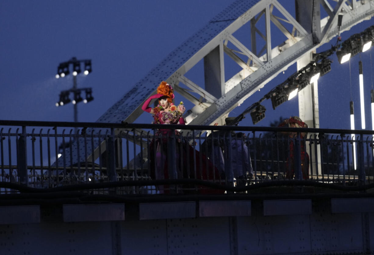 FILE - Drag queens prepare to perform on the Debilly Bridge in Paris, during the opening ceremony of the 2024 Summer Olympics, Friday, July 26, 2024. A storm of outrage about the Paris Olympics&rsquo; opening ceremony took a legal turn Tuesday July 30, 2024, with a DJ who performed at the show saying her lawyer is filing complaints over a torrent of threats and other abuse that the LGBTQ+ icon has suffered online in the ceremony&rsquo;s wake.