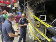 Officials assess a small building after a fire in Manila Friday, Aug. 2, 2024. A fire swept through a part of the small building in Manila&rsquo;s crowded Chinatown district Friday, police said, adding that an investigation was underway to determine the cause of the blaze.