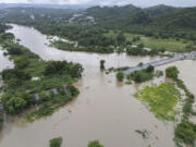 La Plata river floods a road after Tropical Storm Ernesto passed through Toa Baja, Puerto Rico, Wednesday, Aug. 14, 2024.