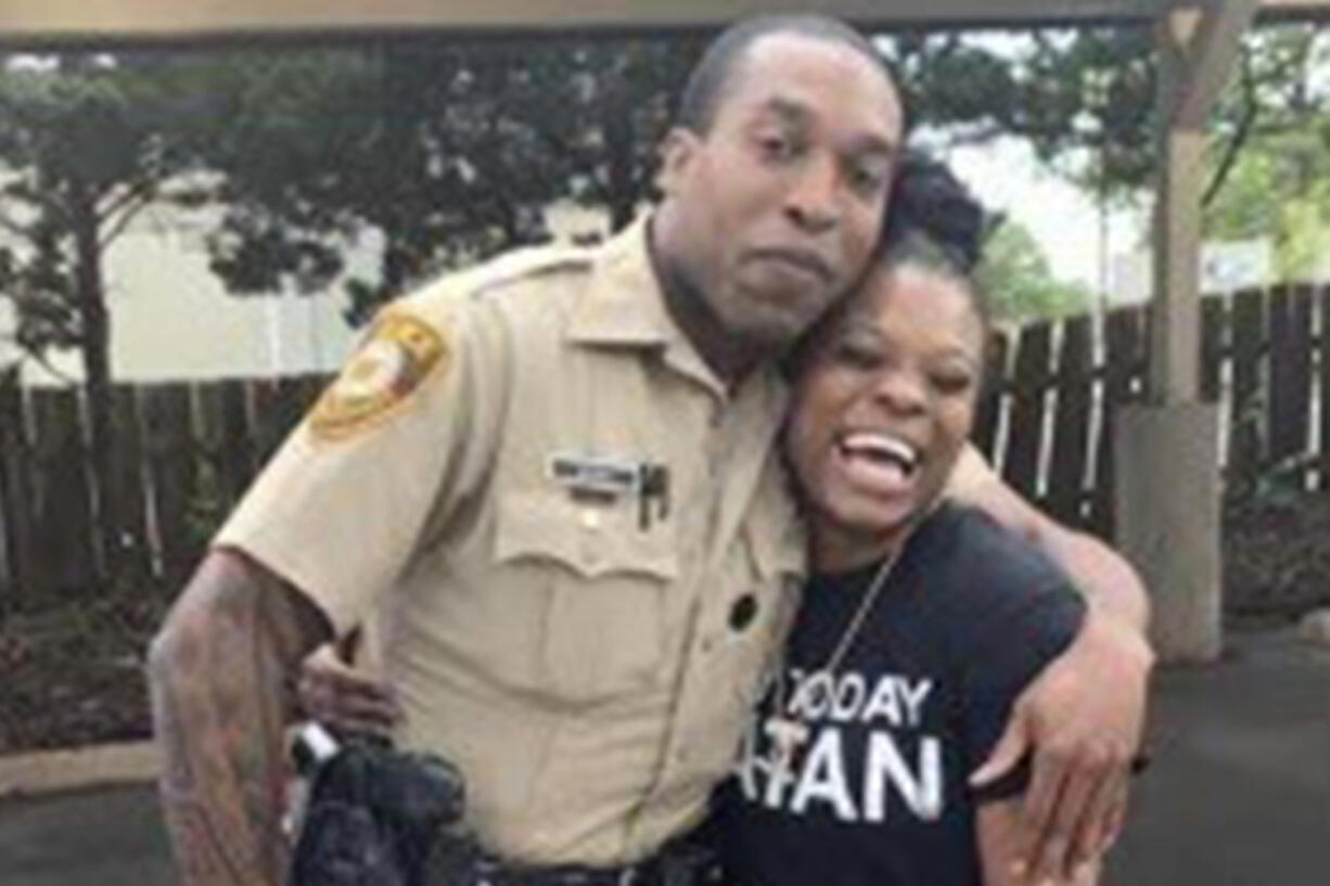 In this undated photo provided by Charlene Jefferson in August 2024, Travis Brown, when he was St. Louis County police officer, stands with Danielle Oliver. Brown, a Ferguson Police officer, suffered a severe brain injury after he was knocked to the ground Friday, Aug. 9, 2024, during a protest in Ferguson, Mo., on the 10th anniversary of the shooting death of Michael Brown.