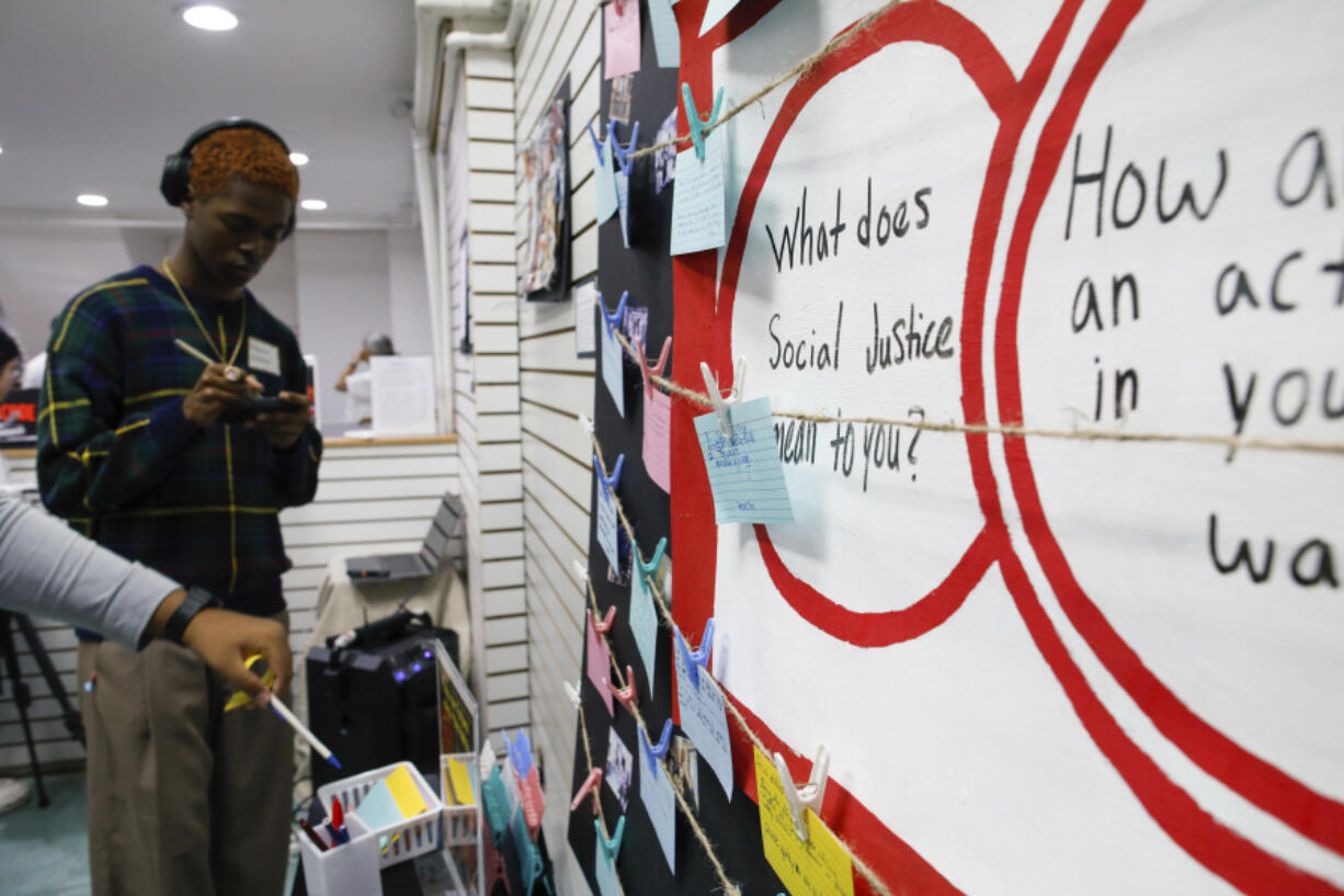 People place written messages about the meaning of social justice during the opening of an art contest titled &ldquo;Hacked the Hate&rdquo; made by young artists, Thursday, Aug. 8, 2024, in New York.