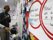 People place written messages about the meaning of social justice during the opening of an art contest titled &ldquo;Hacked the Hate&rdquo; made by young artists, Thursday, Aug. 8, 2024, in New York.