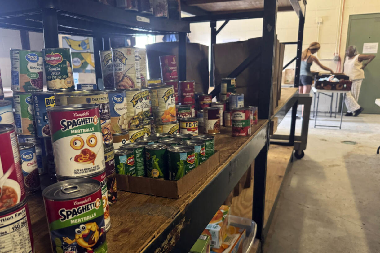 Stacks of donated goods line the shelves at the Good News Outreach food bank, Wednesday, July 31, 2024, in Tallahassee, Fla. Florida is one of 13 states that is not participating in a federal hunger relief program this summer that helps families in need buy groceries.