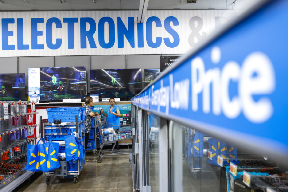 FILE - People walk around a Walmart Superstore in Secaucus, New Jersey, on July 11, 2024.