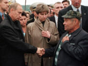 FILE - Russian President Vladimir Putin greets an unidentified relative of a seaman who was believed killed aboard the nuclear submarine Kursk at the military base of Vedyayevo, 50 miles (80 kilometers) north of Murmansk, Russia, on Aug. 22, 2000.