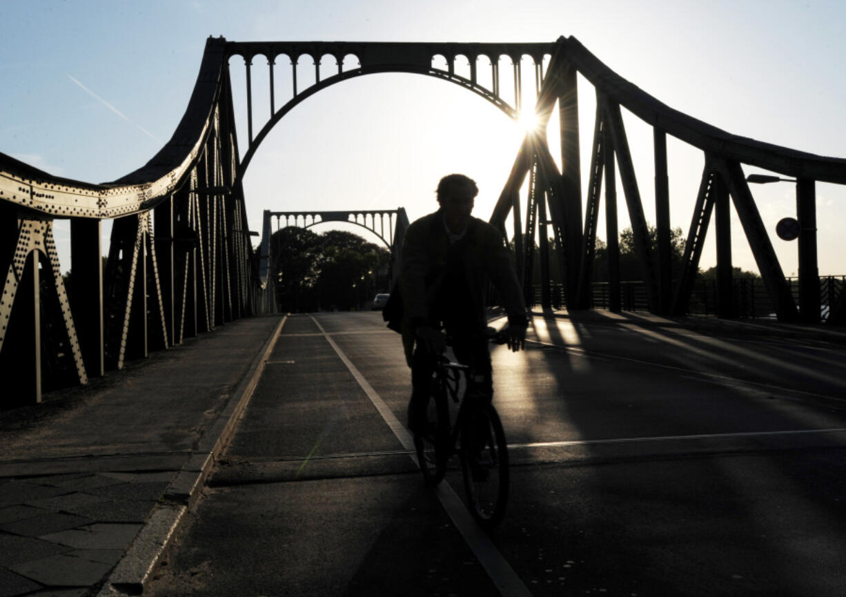 FILE - A cyclist passes over the Glienicke Bridge between Potsdam and Berlin, Germany, on May 6, 2009. They sometimes see those who are part of the swap as they pass each other on an airport tarmac or, as in the Cold War, the Glienicke Bridge connecting West Berlin to Potsdam. In decades of prisoner exchanges, those released have included spies, journalists, drug and arms dealers, and even a well-known athlete.