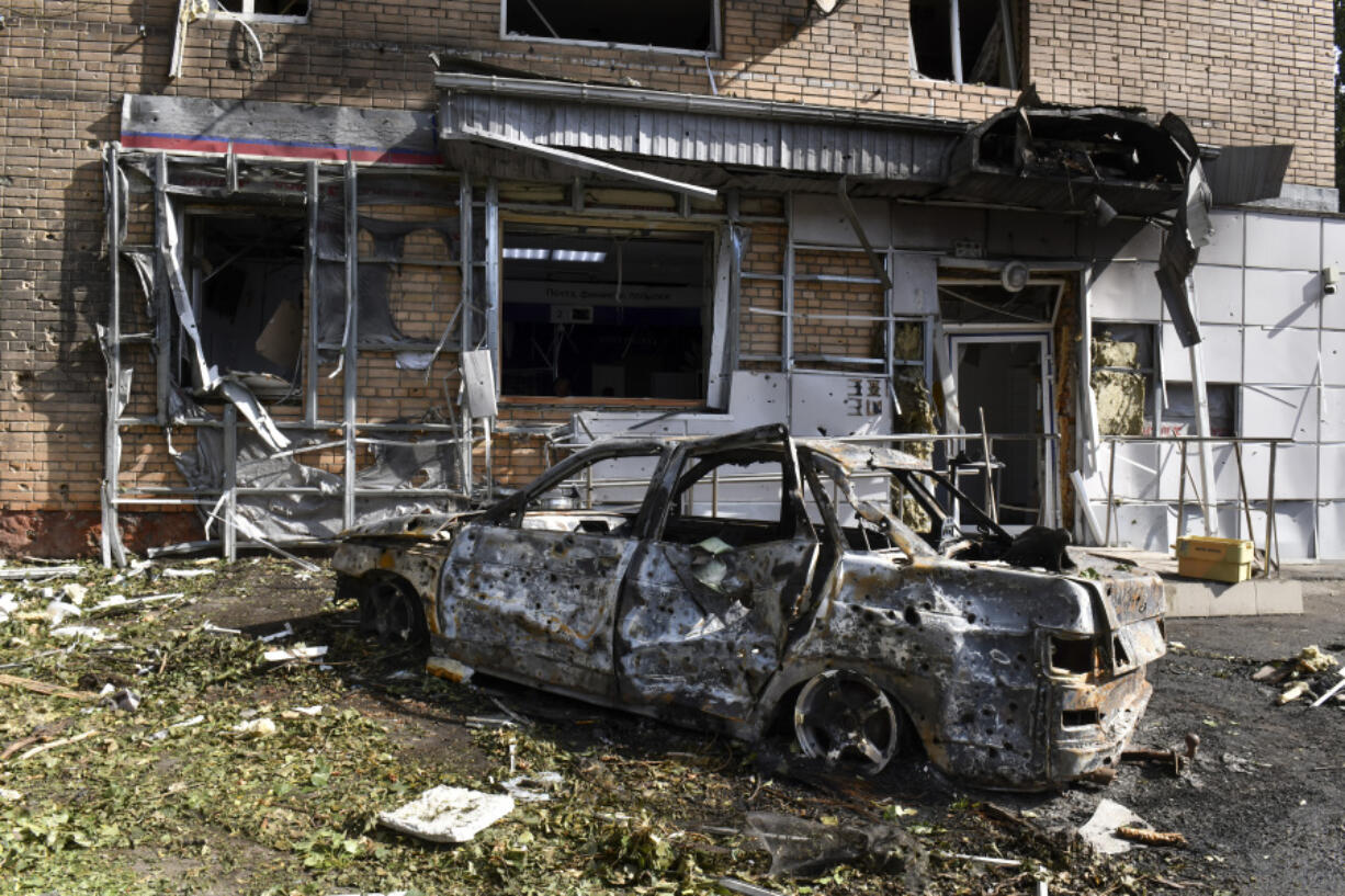 A burned car is seen in front of an apartment building damaged after shelling by the Ukrainian side in Kursk, Russia, Sunday, Aug. 11, 2024.