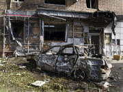 A burned car is seen in front of an apartment building damaged after shelling by the Ukrainian side in Kursk, Russia, Sunday, Aug. 11, 2024.