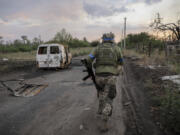 In this photo provided by Ukraine&#039;s 24th Mechanised Brigade press service, a serviceman of the 24th Mechanised Brigade runs past a damaged car at the frontline town of Chasiv Yar, Donetsk region, Ukraine, Tuesday, Aug. 6, 2024.