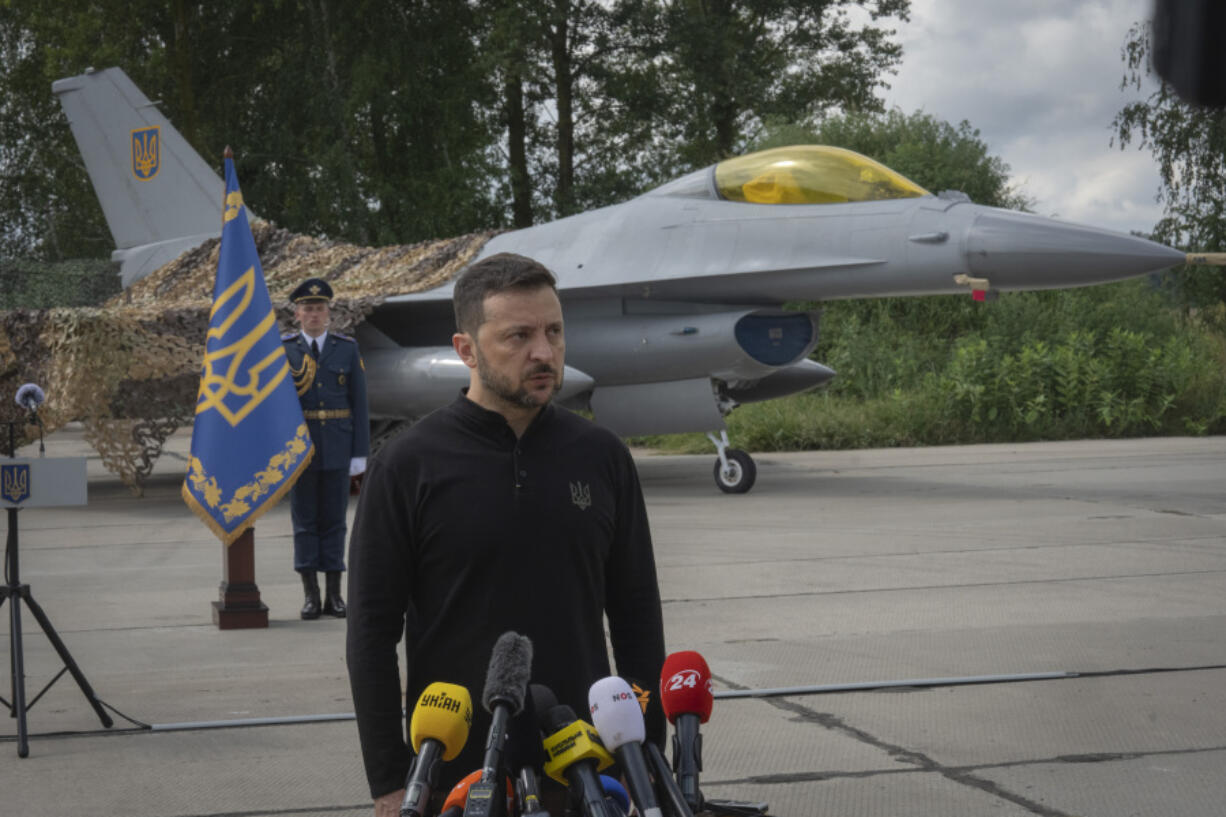 Ukraine&#039;s President Volodymyr Zelenskyy answers media questions standing against the background of Ukraine&#039;s Air Force&#039;s F-16 fighter jets in an undisclosed location in Ukraine, Sunday, Aug. 4, 2024. The F-16 fighter jets that have been delivered to Ukraine by Western countries will be flying sorties in Ukrainian skies and helping the country&#039;s current fleet of Soviet-era jets to counter Russia&#039;s invasion.