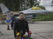 Ukraine&#039;s President Volodymyr Zelenskyy answers media questions standing against the background of Ukraine&#039;s Air Force&#039;s F-16 fighter jets in an undisclosed location in Ukraine, Sunday, Aug. 4, 2024.