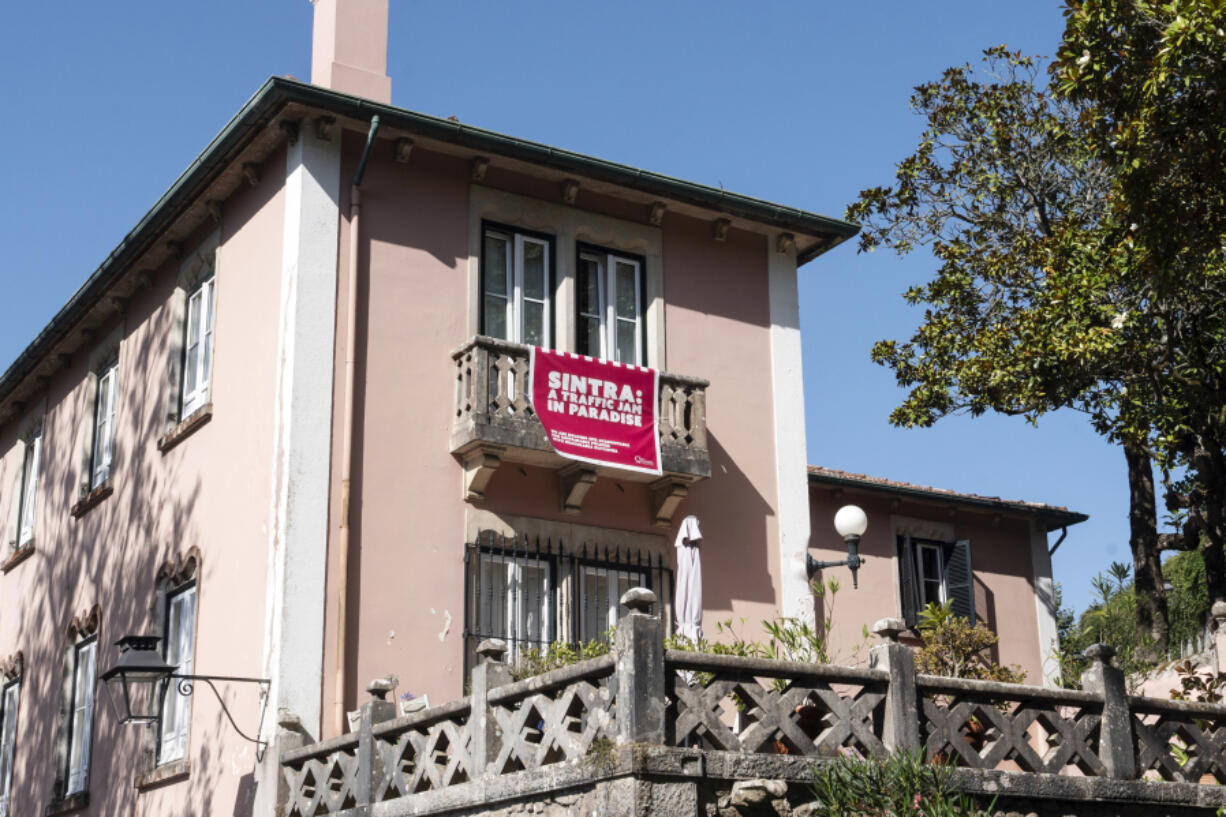 A poster hanging from a balcony reads &ldquo;Sintra: A traffic jam in paradise&rdquo;, in Sintra, Portugal, Friday, Aug. 9, 2024.