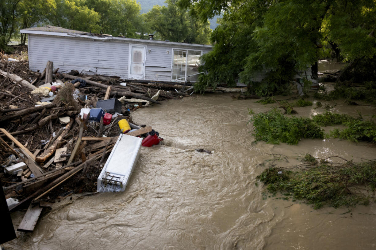 A mobile home swept from its foundation is seen lodged about 1,000 feet away from the property where it stood near a bridge on the Canisteo River, Friday, Aug. 9, 2024, in Canisteo, N.Y., after remnants of Tropical Storm Debby swept through the area.