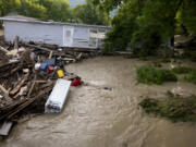 A mobile home swept from its foundation is seen lodged about 1,000 feet away from the property where it stood near a bridge on the Canisteo River, Friday, Aug. 9, 2024, in Canisteo, N.Y., after remnants of Tropical Storm Debby swept through the area.