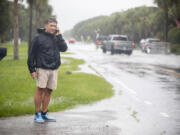 City of Isle of Palms councilman John Bogosian calls local officials informing them flooding water on Palm Blvd as Tropical Storm Debby approaches, Tuesday, Aug. 6, 2024, in Isle of Palms, S.C.