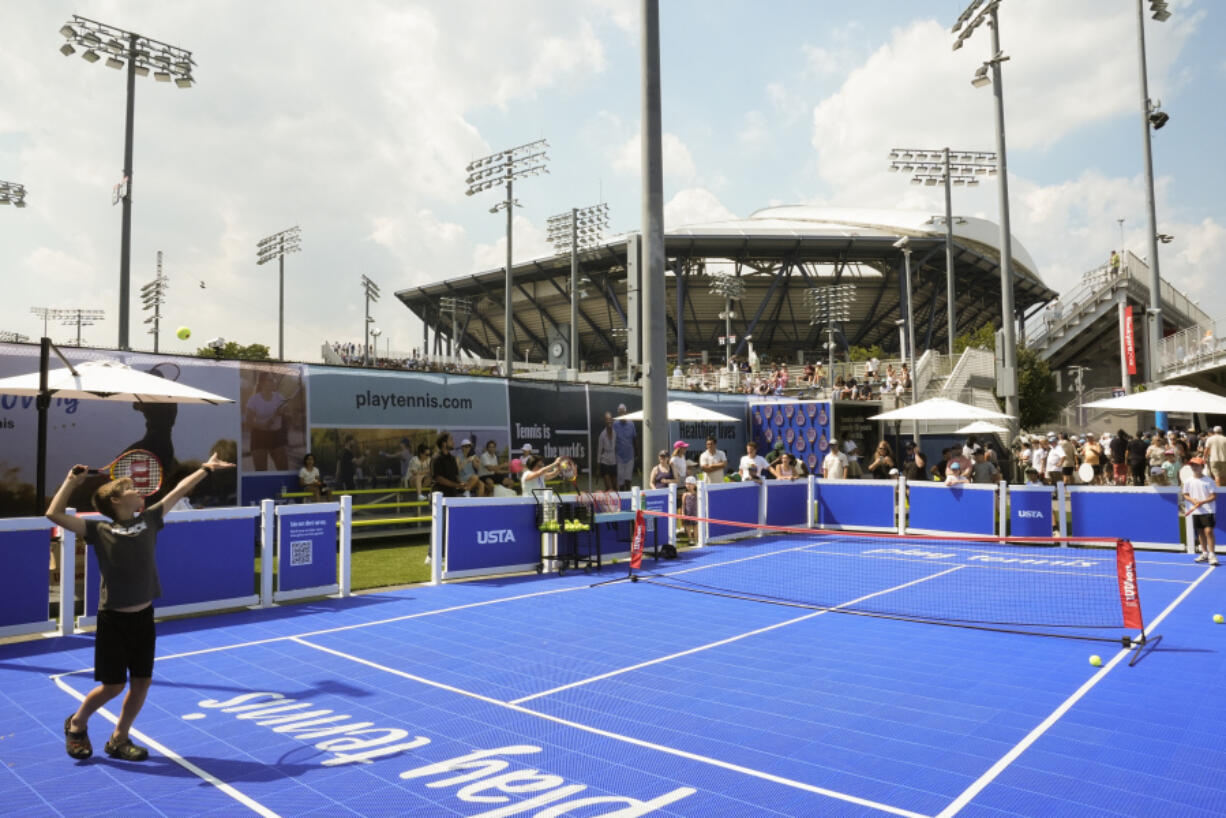 Ten-year-old Jack Jacobs serves to Jack Balsam, 11, as they play a version of tennis resembling pickleball on the grounds of the Billie Jean King National Tennis Center during the first round of the U.S. Open tennis championships, Monday, Aug. 26, 2024, in New York.