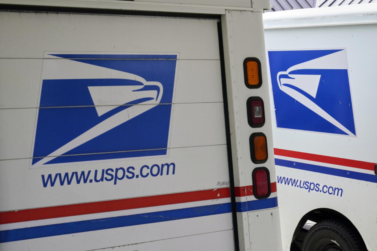 FILE - U.S. Postal Service delivery vehicles are parked outside a post office in Boys Town, Neb., Aug. 18, 2020.