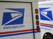 FILE - U.S. Postal Service delivery vehicles are parked outside a post office in Boys Town, Neb., Aug. 18, 2020.