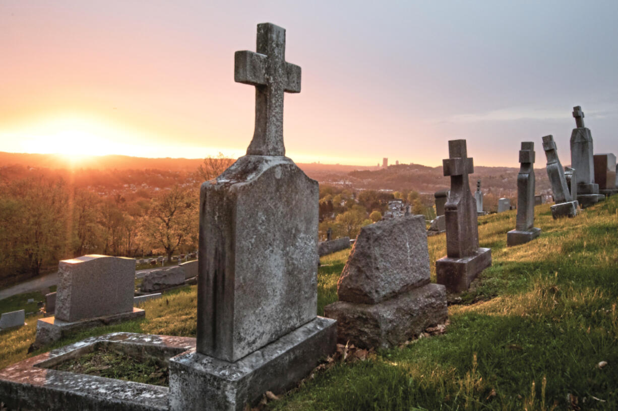 FILE - The sun rises on St. Mary&rsquo;s Cemetery, April 19, 2019, in McKees Rocks, Pa.