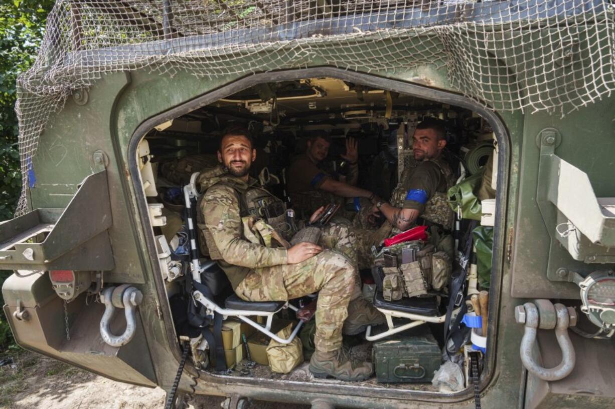 Ukrainian servicemen sit inside their APC after returning from Russian Kursk region, near Russian-Ukrainian border, Sumy region, Ukraine, Wednesday, Aug. 14, 2024.