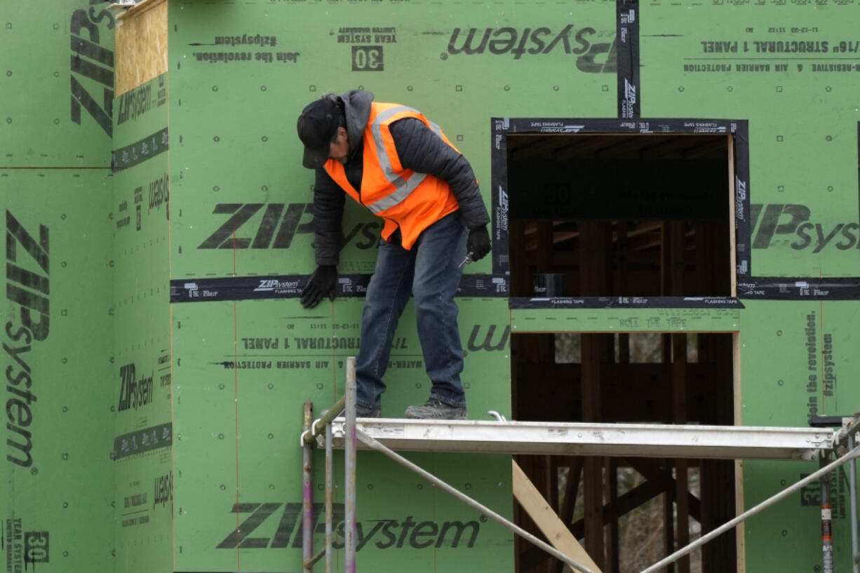 FILE - A construction worker secures sheathing at a residential building site in Mount Prospect, Ill., on March 18, 2024. (AP Photo/Nam Y.