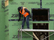 FILE - A construction worker secures sheathing at a residential building site in Mount Prospect, Ill., on March 18, 2024. (AP Photo/Nam Y.