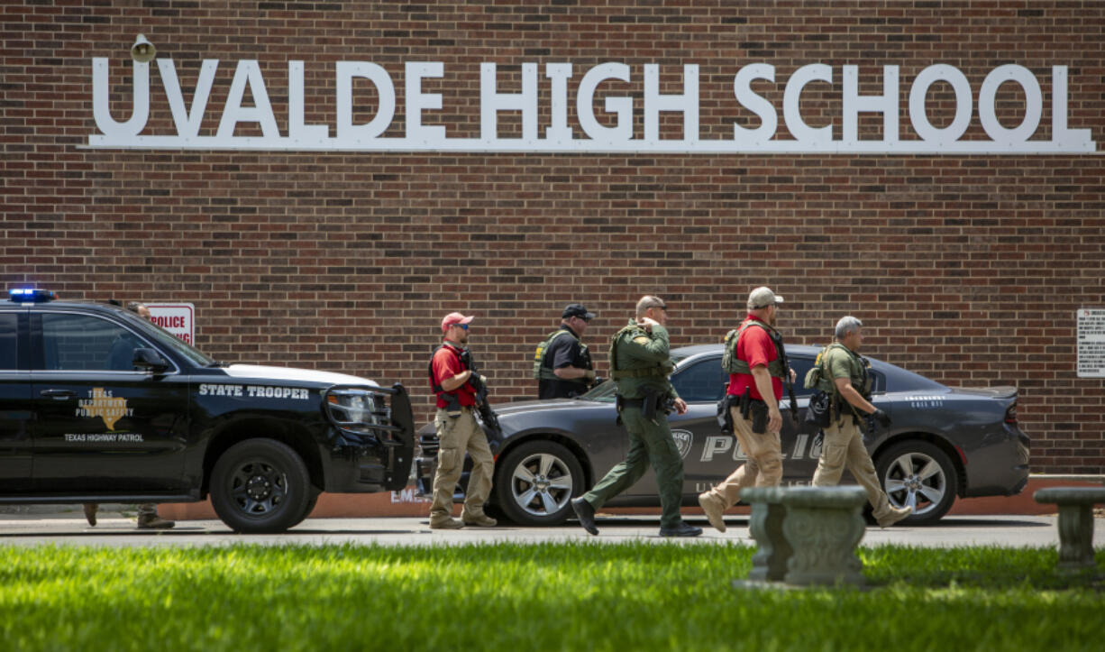 FILE - Law enforcement personnel walk outside Uvalde High School after shooting a was reported earlier in the day at Robb Elementary School, Tuesday, May 24, 2022, in Uvalde, Texas.